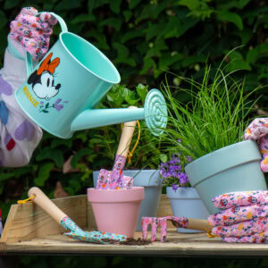 Sfeerfoto van een kindergieter en plantenpotjes in de tuin